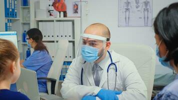 enfant et médecin avec protection masque parlant et en riant dans médical Bureau pendant corona virus. médecin spécialiste dans médicament fournir santé se soucier prestations de service consultation traitement dans hôpital. photo