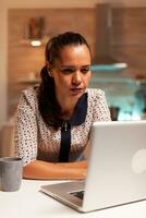 femme d'affaires squiter yeux car de épuisement tandis que travail sur une projet en retard à nuit de maison. employé en utilisant moderne La technologie à minuit Faire heures supplémentaires pour emploi, entreprise, carrière, réseau, mode de vie. photo