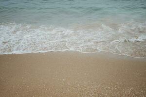 vague s'écraser sur chaud le sable photo