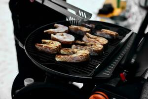 homme grillage délicieux poisson sur une portable un barbecue, neigeux hiver barbecue photo