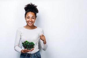 le concept d'une alimentation saine, fille tenant un bol de salade, sur fond blanc, alimentation saine