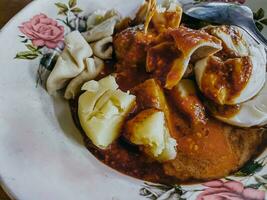 siomay bandung sur une petit assiette servi sur une en bois table avec épicé cacahuète sauce. siomay bandung ''shaomai'' est connu comme une type de dimsum nourriture mixte avec des légumes et épicé cacahuète sauce. proche en haut. photo