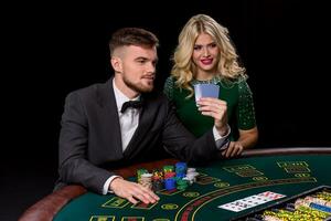 vue de jeune, confiant, homme avec le Dame tandis que il est en jouant poker jeu. photo