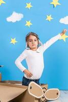 peu rêveur fille en jouant avec une papier carton avion à le studio avec bleu ciel et blanc des nuages Contexte. photo