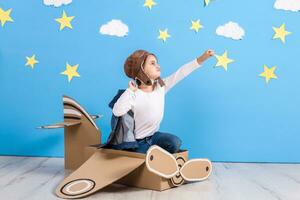 peu enfant fille dans une du pilote costume est en jouant et rêver de en volant plus de le des nuages. photo