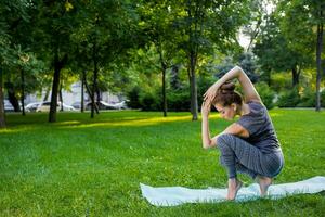 Jeune femme Faire yoga des exercices dans le été ville parc. photo