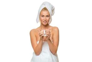 Jeune attrayant femme dans serviette en portant une tasse photo