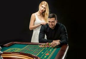 Hommes avec femmes en jouant roulette à le casino. photo