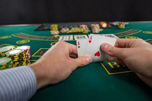 Masculin poker joueur levage le coins de deux cartes as photo