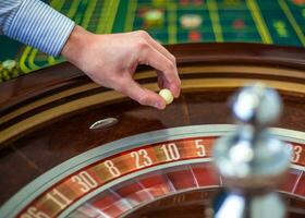 roulette roue et croupier main avec blanc Balle dans casino photo