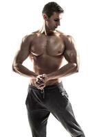 musclé homme poser, fléchissement le sien biceps, montrant parfait corps. photo