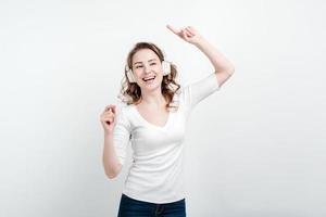 fille souriante dans les écouteurs dansant. isolé sur fond blanc. photo