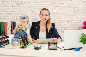 maman et femme d'affaires travail avec portable ordinateur à Accueil et en jouant avec sa bébé fille. photo