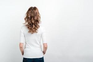 fille avec le dos tourné, posant isolé sur fond blanc. espace libre. photo