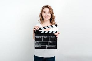 femme tenant un panneau de clapet de production de film regardant la caméra photo