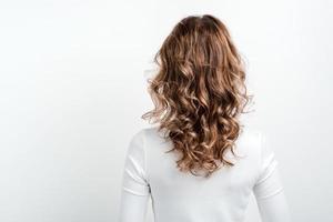 Femme blonde debout contre un arrière-plan de studio retour à la caméra photo