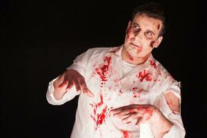 diable à l'intérieur une homme avec sanglant Créatif faire en haut plus de noir Contexte. Halloween costume. photo