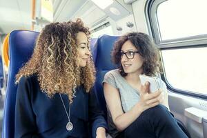 deux souriant charmant les filles en utilisant une téléphone intelligent photo