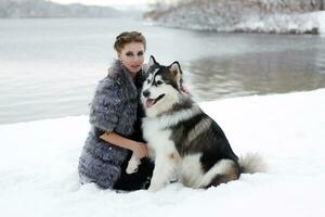 Jeune femme avec Loup chien dans neige photo