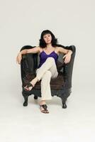 portrait de une étourdissant à la mode modèle séance dans une chaise photo