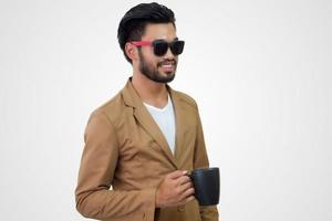 portrait d'un beau jeune homme d'affaires asiatique tenant une tasse de café. isolé sur fond blanc. photo