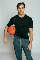 Beau Jeune souriant homme porter une basketball Balle photo