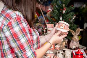 femme choisir Noël cadeaux à petit artisanat poterie magasin. l'hiver vacances ambiance dans tropical climat. photo
