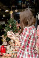 femme choisir Noël cadeaux à petit artisanat poterie magasin. l'hiver vacances ambiance dans tropical climat. photo