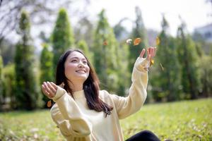 belle femme asiatique souriante fille heureuse et portant des vêtements chauds portrait d'hiver et d'automne à l'extérieur dans le parc
