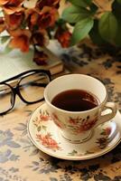 ai généré une style vintage photo de une café tasse sur une soucoupe avec une journal et paire de des lunettes