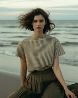 ai généré une femme permanent sur une plage dans une rayé chemise, photo