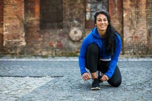 magnifique Jeune sportif femme est attacher lacet Extérieur. photo