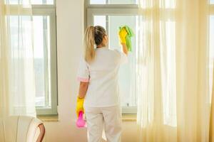 image de Hôtel Femme de ménage nettoyage les fenêtres dans une chambre. photo