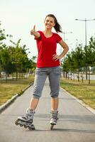 sportif fille sur rouleau patins montrant pouce en haut photo