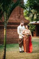 la mariée asiatique et le marié caucasien passent un moment romantique avec une robe thaïlandaise photo