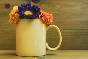 magnifique fleur pétales dans une tasse sur en bois Contexte. photo