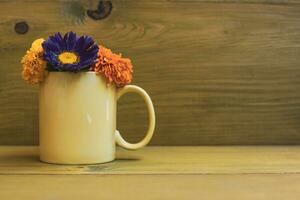 magnifique fleur pétales dans une tasse sur en bois Contexte. photo