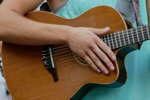 une homme en jouant un acoustique guitare dans une parc photo