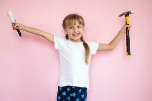 concept de construction et de personnes - petite fille souriante avec un marteau photo