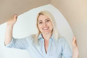 souriant Jeune femme ouverture une carton boîte, déménagement et déballage concept photo