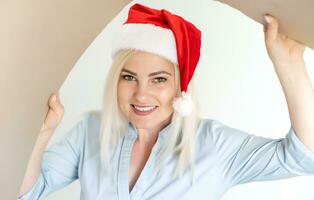 Noël, livraison et hiver vacances concept - content Jeune femme dans Père Noël assistant chapeau à la recherche dans ouvert cadeau boîte photo