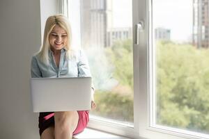 Jeune femme en utilisant portable ordinateur. femme d'affaires travail à maison. en ligne achats, commerce électronique, l'Internet bancaire, dépenses argent, travail de Accueil concept photo