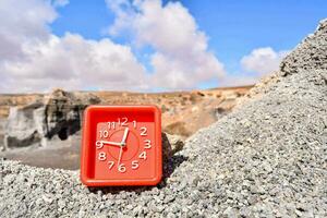 une rouge l'horloge séance sur Haut de une falaise photo