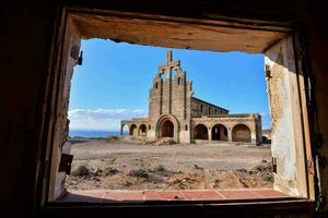 le vue de un abandonné église par une fenêtre photo