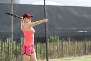 femme en jouant tennis en portant une raquette et souriant photo