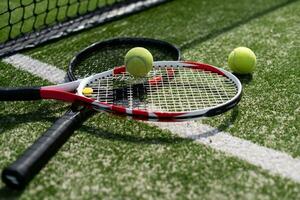 une raquette de tennis et une nouvelle balle de tennis sur un court de tennis fraîchement peint photo