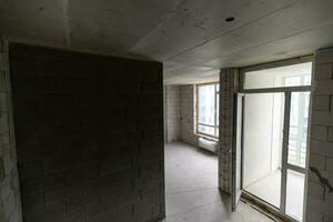 petit appartement sans pour autant réparation dans une Nouveau bâtiment. une pièce dans un inachevé maison. des murs de mousse bloquer et béton sol dans une minuscule appartement. photo