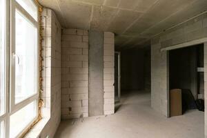 petit appartement sans pour autant réparation dans une Nouveau bâtiment. une pièce dans un inachevé maison. des murs de mousse bloquer et béton sol dans une minuscule appartement. photo