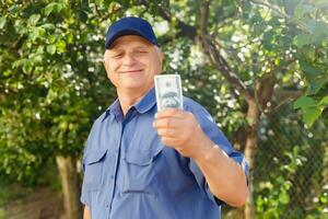 un personnes âgées homme en portant une empiler de argent photo