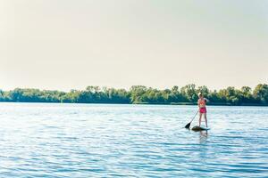 action coup de Jeune femme sur pagayer planche photo